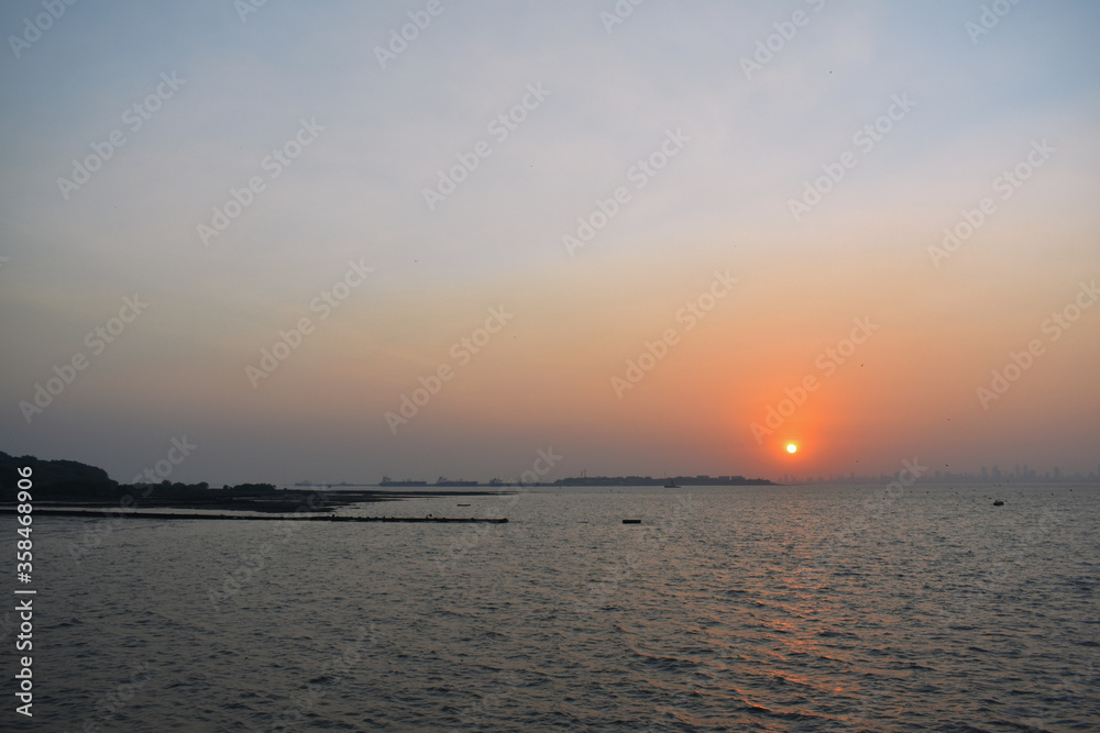 sun setting in the shore of mumbai just beside the ocean