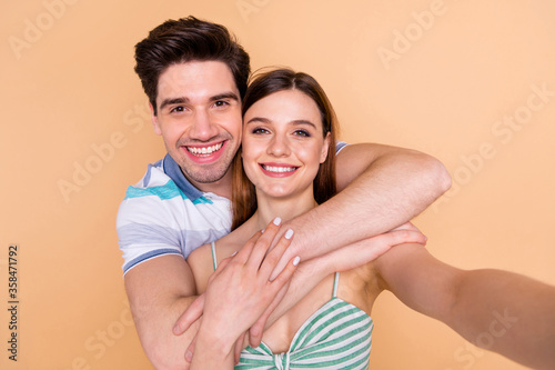 Self-portrait of his he her she nice attractive lovely pretty affectionate careful cute cheerful cheery couple spending vacation weekend free time embracing isolated over beige pastel color background #358471792