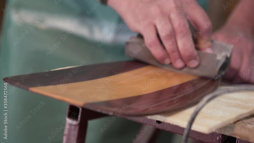 Man in the shop polishing paddle Man in the shop polishing paddle