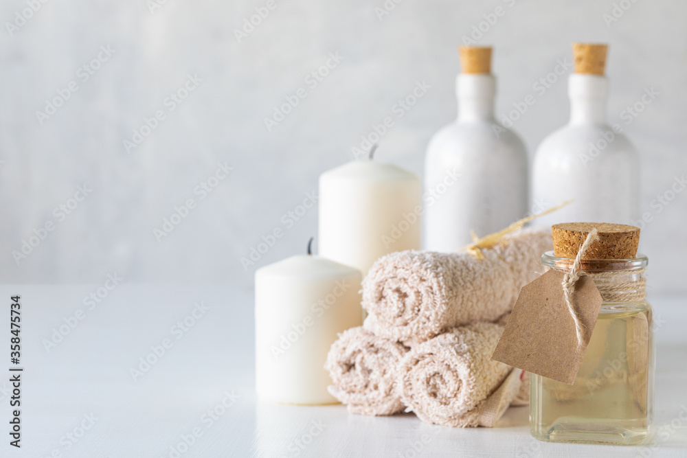 Essential oil, candles and towels on a white background. Spa and wellness concept. Essential oil, candles and towels on a white background. Spa and wellness concept.