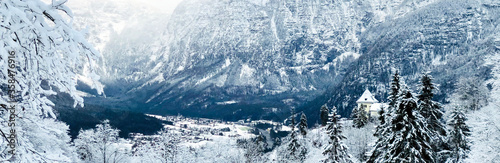 Panorama of Hallstatt Winter snow mountain landscape valley and lake through the forest in upland valley leads to the old salt mine of Hallstatt, Austria