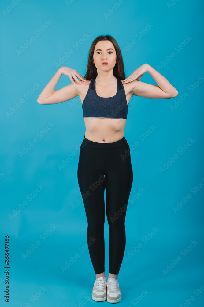 sport girl performs workout on blue background