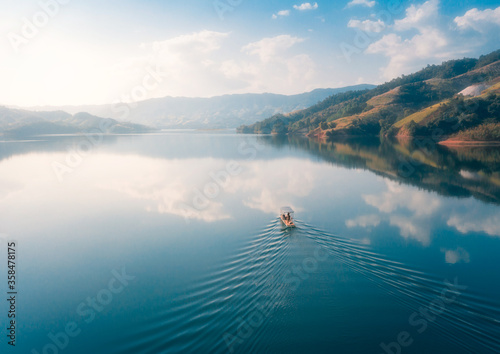 A boat sailing in lake with mountains around © wang