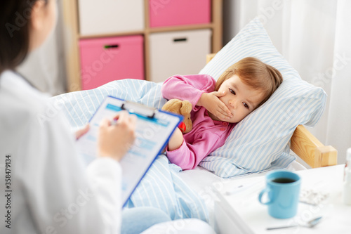 healthcare, medicine and people concept - doctor with clipboard and sick coughing little girl lying in bed at home