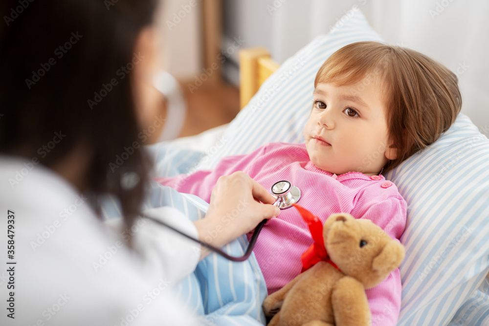 healthcare, medicine and people concept - doctor with stethoscope checking sick little girl's lungs at home healthcare, medicine and people concept - doctor with stethoscope checking sick little girl's lungs at home