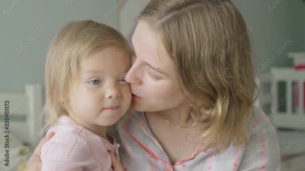 Slow motion. Close-up. Portrait. A pregnant woman hugs and kisses her little daughter. Slow motion. Close-up. Portrait. A pregnant woman hugs and kisses her little daughter.
