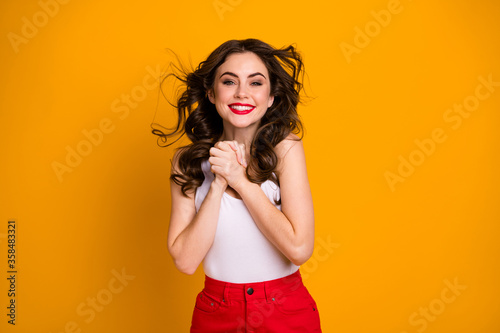 Photo of funny pretty lady hairstyle flight satisfied look warm breeze summer evening day hands together overjoyed wear white casual singlet red skirt isolated yellow color background © deagreez