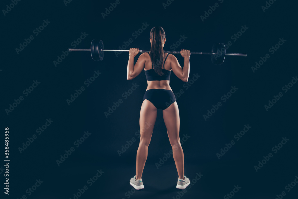 Full size rear behind photo active short sport suit lady heavy barbell shoulders competition isolated black background Full size rear behind photo active short sport suit lady heavy barbell shoulders competition isolated black background