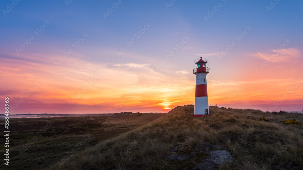 Lighthouse Sylt List east - Ellenbogen at sunset with beautiful red and yellow clouds - high dynamic range