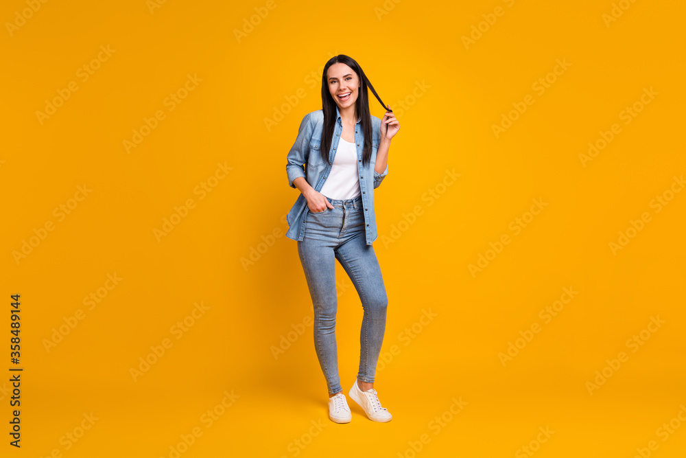 Full length body size view of her she nice-looking attractive charming glad cheerful cheery girl enjoying good mood touching curl hair isolated on bright vivid shine vibrant yellow color background Full length body size view of her she nice-looking attractive charming glad cheerful cheery girl enjoying good mood touching curl hair isolated on bright vivid shine vibrant yellow color background