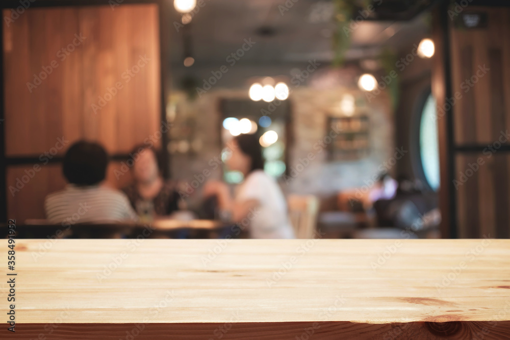 Empty wooden desk space platform and blurred restaurant or coffee shop background for product display montage. Empty wooden desk space platform and blurred restaurant or coffee shop background for product display montage.