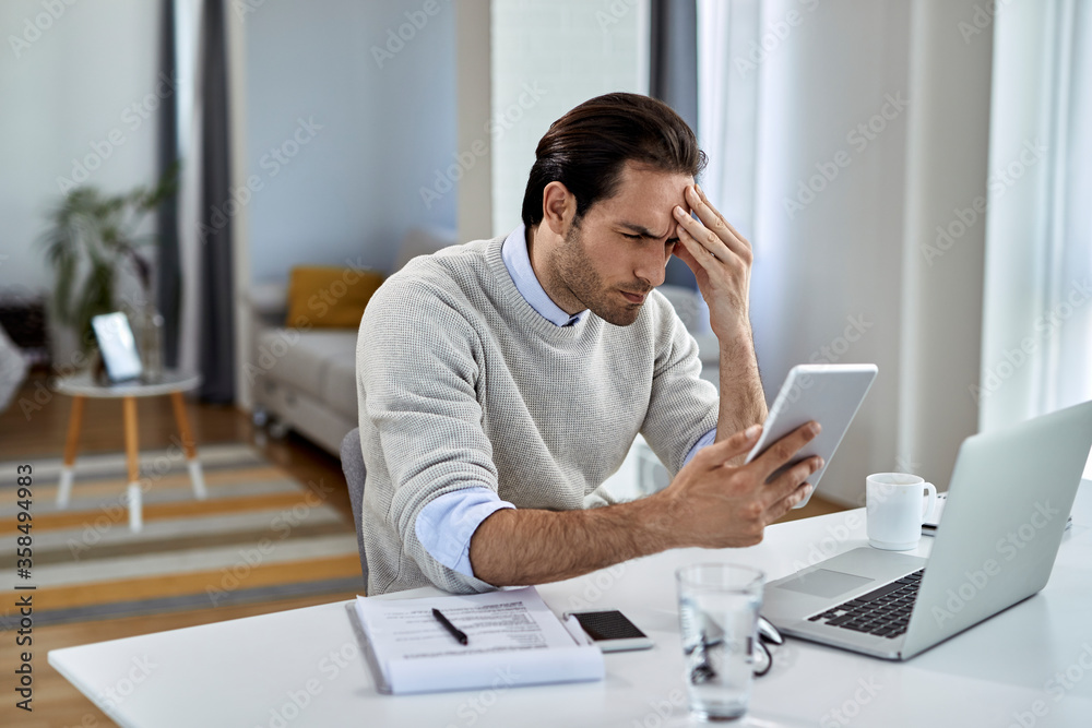 Worried businessman using digital tablet while working at home. Worried businessman using digital tablet while working at home.