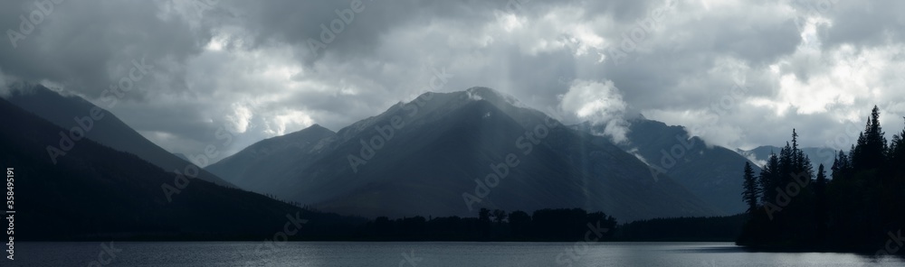 Sun rays peak through dramatic clouds over St Mary Lake in Kimberley, Canada Sun rays peak through dramatic clouds over St Mary Lake in Kimberley, Canada