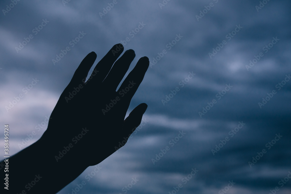 Silhouette of a hand reaching to the dark sky. Silhouette of a hand reaching to the dark sky.