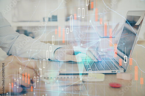 Multi exposure of stock market graph with man working on laptop on background. Concept of financial analysis.