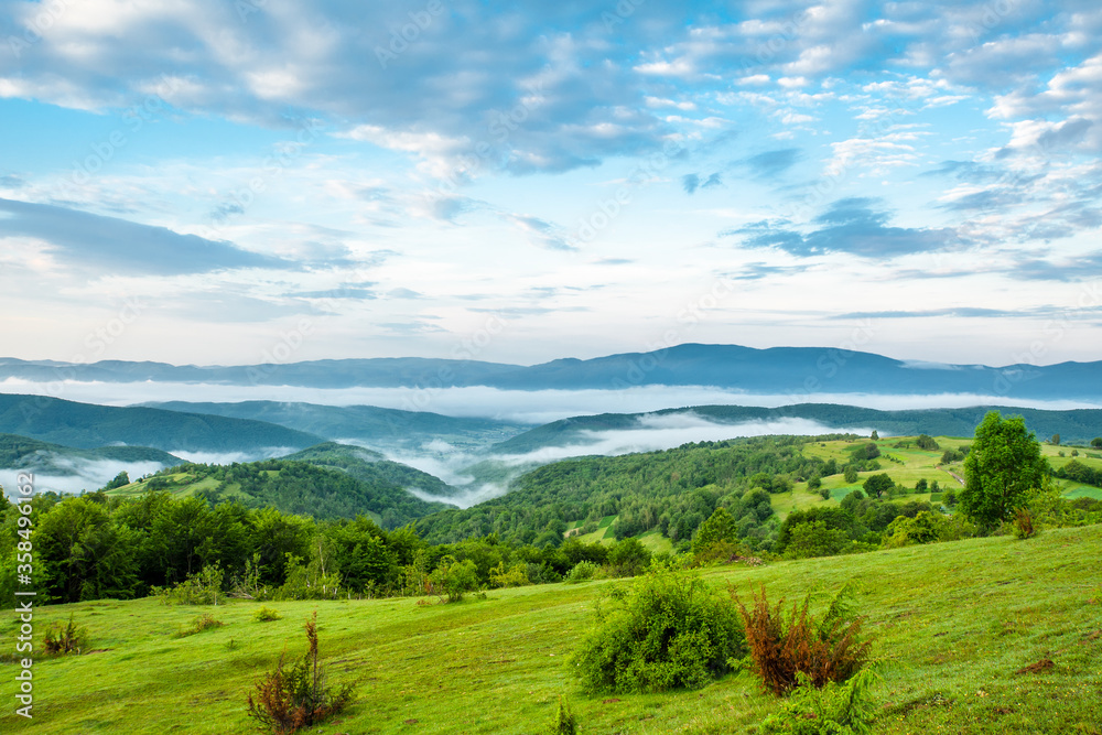 morning in the mountains .green mountains in the fog on a background of mountain peaks and sky.