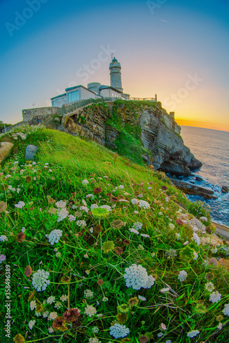 Sunset in the Cabo Mayor lighthouse near city of Santander, Spain, with cliffs, sky and sea. colorful sunset.