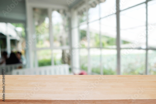 Empty wooden table space platform and blurred restaurant or coffee shop background for product display montage.