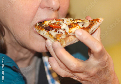 A woman eating pizza, close up