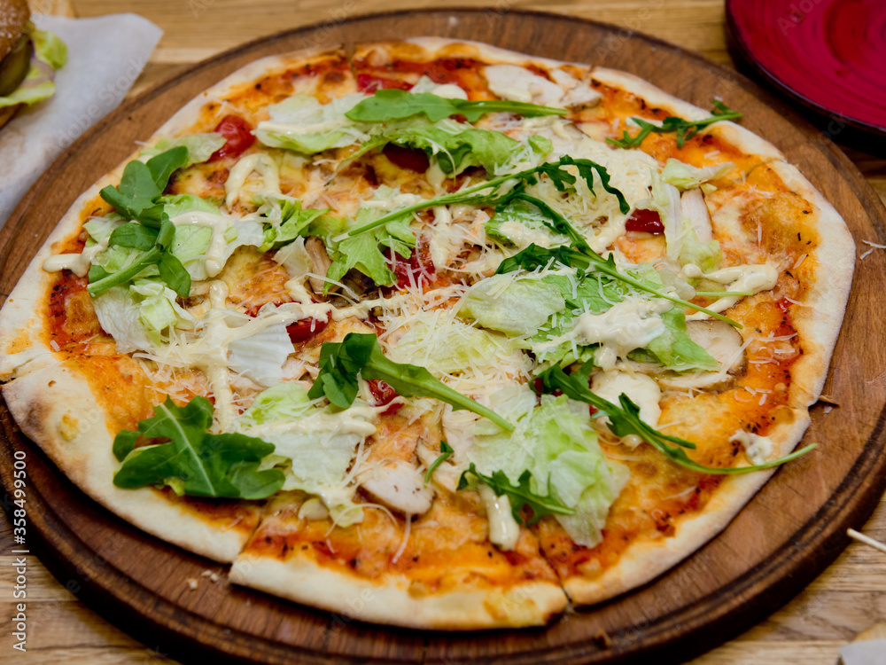 Ready pizza on a wooden plate. Selective focus. Ready pizza on a wooden plate. Selective focus.