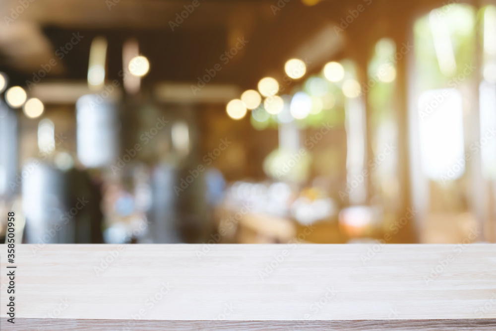 Empty wooden table space platform and blurred restaurant or coffee shop background for product display montage.