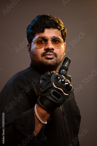 Crazy biker demonstrating offensive behavior showing middle finger in goggles photo