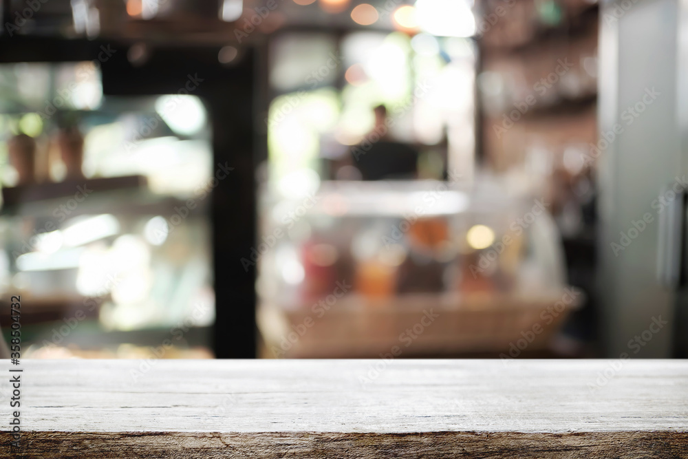Empty wooden desk space platform over blurred restaurant or coffee shop background for product display montage. Empty wooden desk space platform over blurred restaurant or coffee shop background for product display montage.