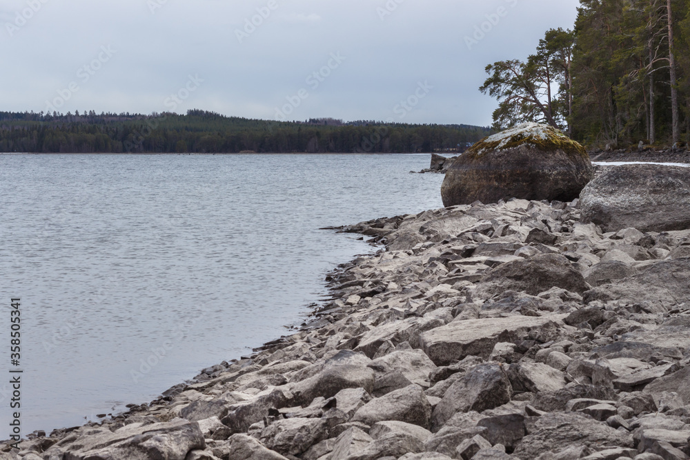 Boulder on the stony shore of the lake Boulder on the stony shore of the lake