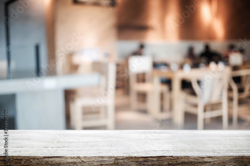 Empty wooden table space platform and blurred restaurant or coffee shop background for product display montage.