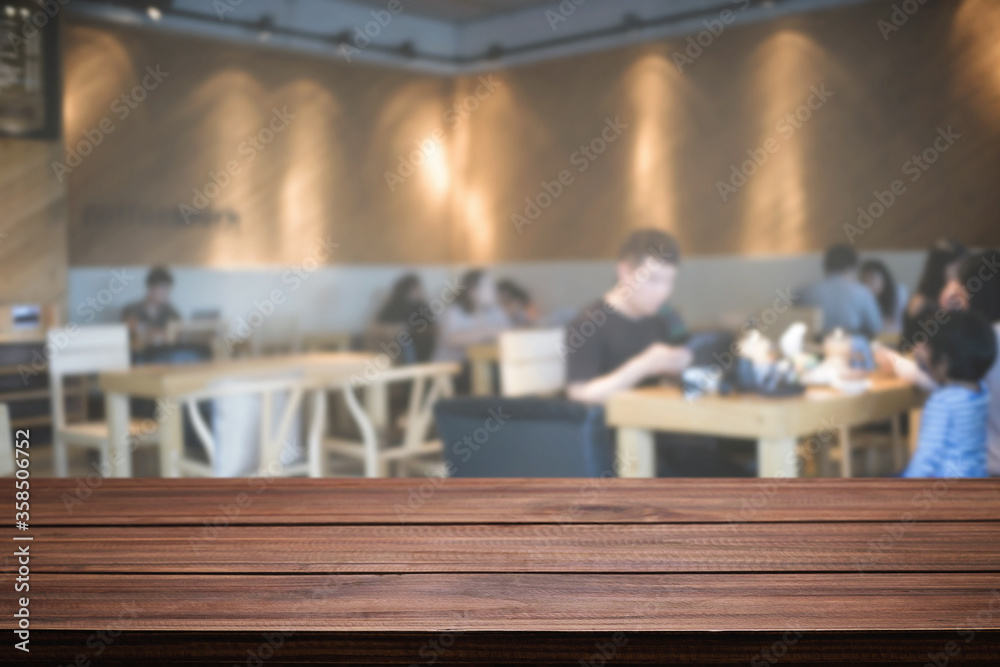Empty wooden desk space platform with blur restaurant or coffee shop background for product display montage.