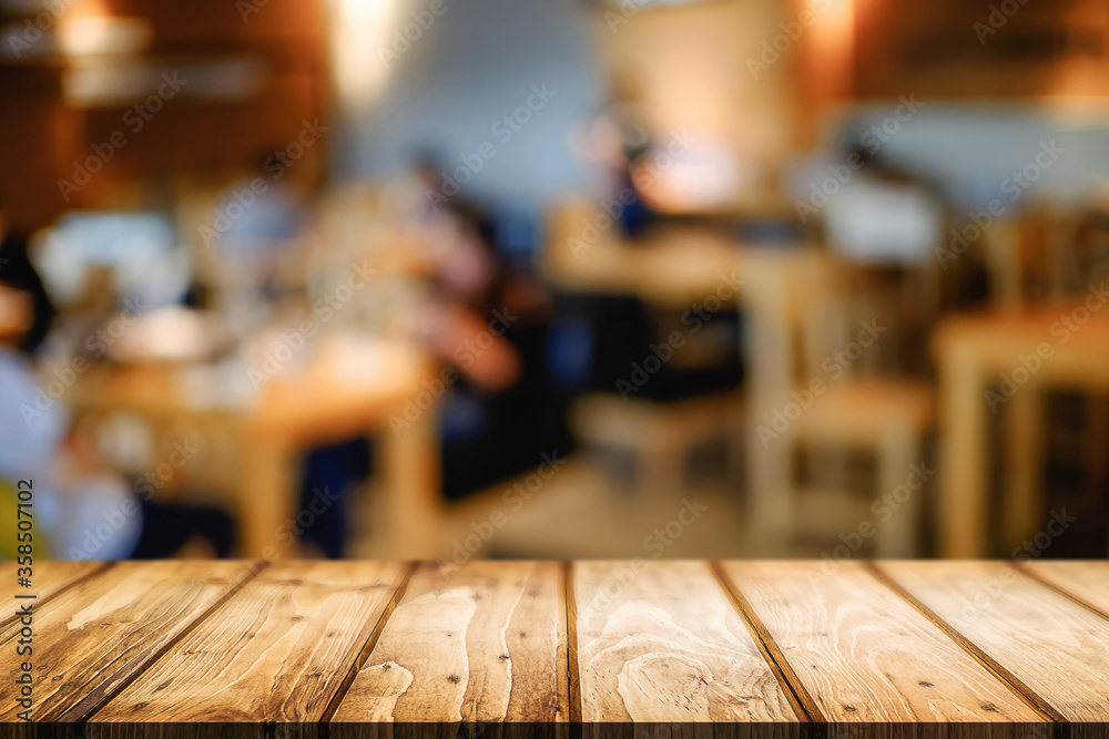 Empty wooden table space platform and blurred resturant or coffee shop background for product display montage.