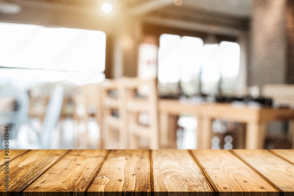Empty wooden desk space platform with blur restaurant or coffee shop background for product display montage. Empty wooden desk space platform with blur restaurant or coffee shop background for product display montage.