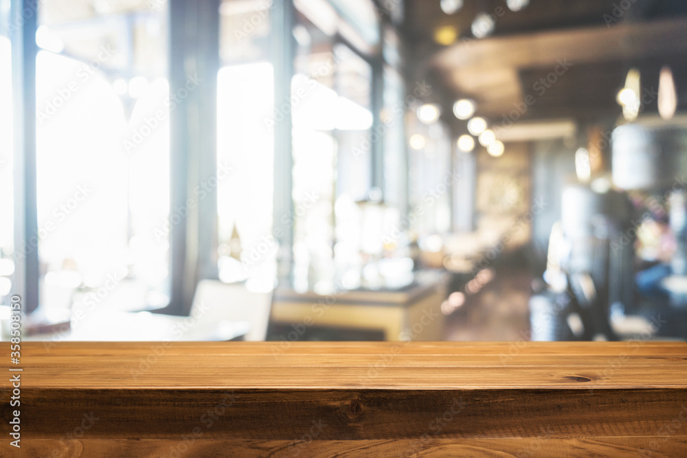 Empty wooden table space platform and blurred resturant or coffee shop background for product display montage.