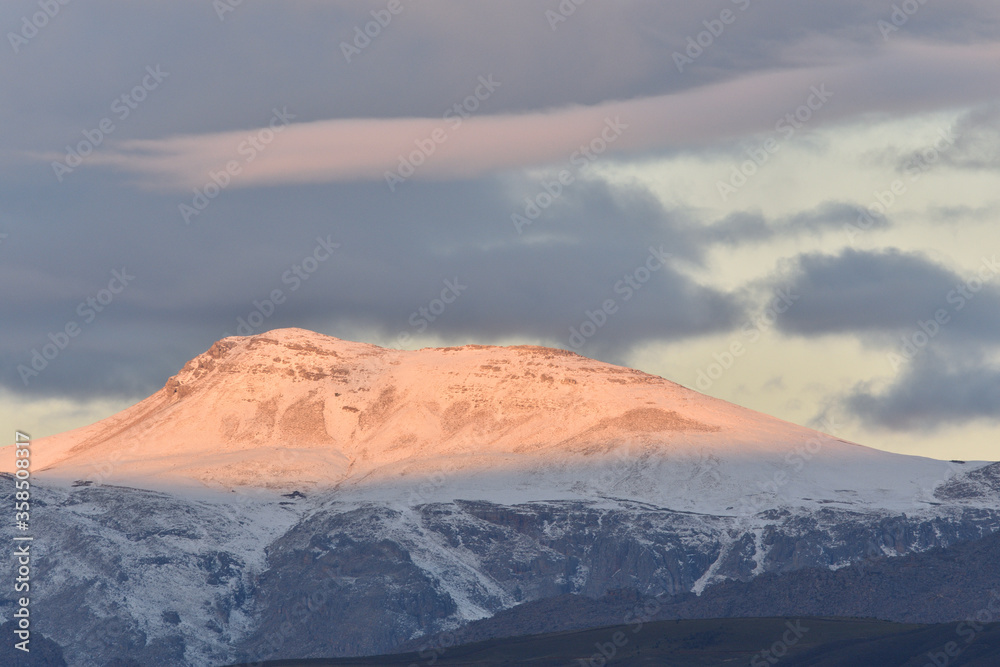 snow covered mountain at sunset