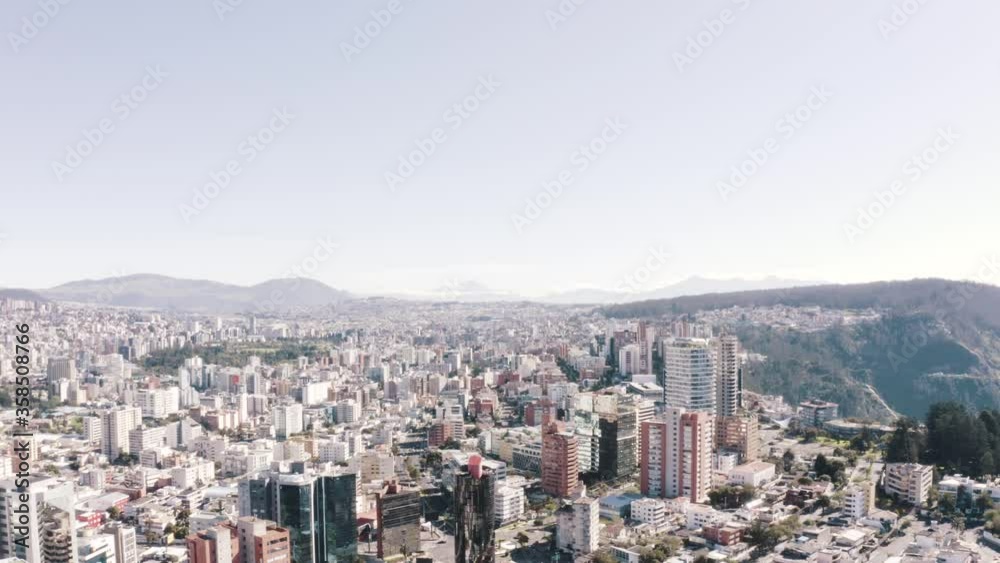 Drone shot of a clear day in the north part of the city of Quito, Ecuador during quarantine. Streets, houses and buildings. Los Andes mountain range, hills and the valleys of the city in the back. Drone shot of a clear day in the north part of the city of Quito, Ecuador during quarantine. Streets, houses and buildings. Los Andes mountain range, hills and the valleys of the city in the back.