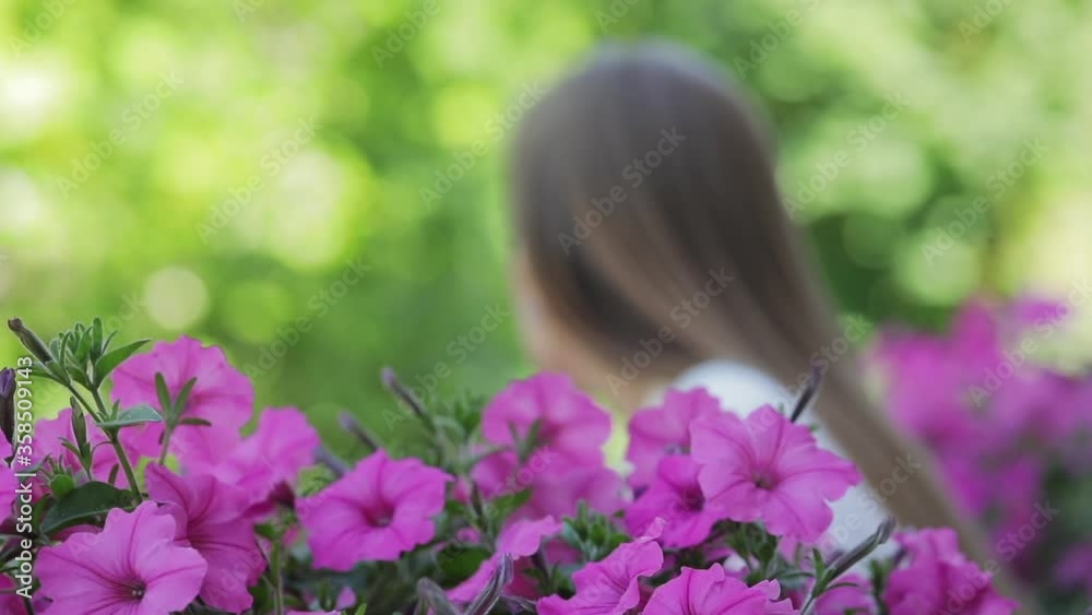Girl on the summer balcony in defocus, summer flowers Girl on the summer balcony in defocus, summer flowers