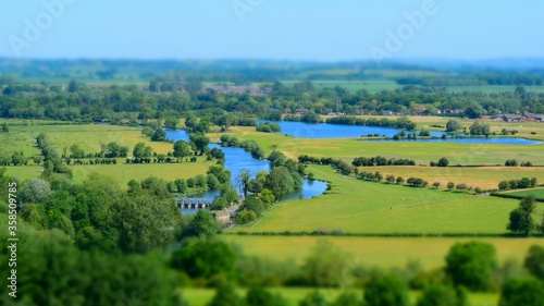 Wide angle shot of a large landscape in Wittenham Clumps, UK full of trees and water photo