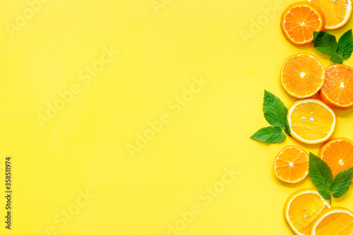 Sliced citrus fruits on yellow background top view