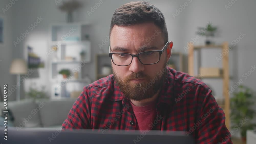 Bearded man using computer for remote work at home. Bearded man using computer for remote work at home.