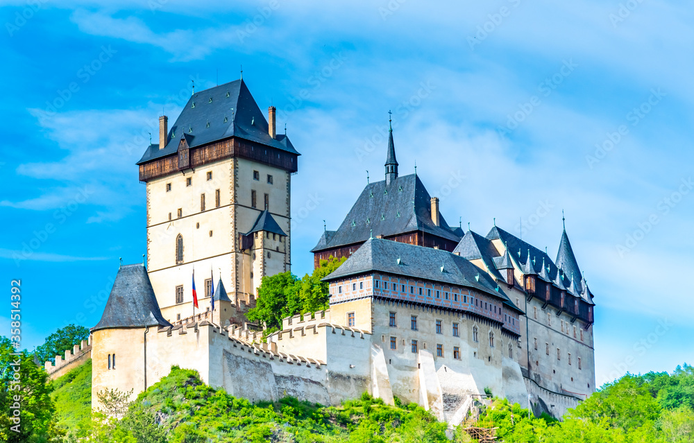 View of the famous Karlstejn castle, Czech republic. Castle built in gothic style by king and emperor of Roman rise, Charles IV. Czech historic heritage, beautiful summer day.
