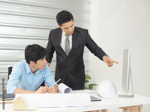 Asian businessman and architect or engineer are discussing work together in office.Man pointing at screen.
