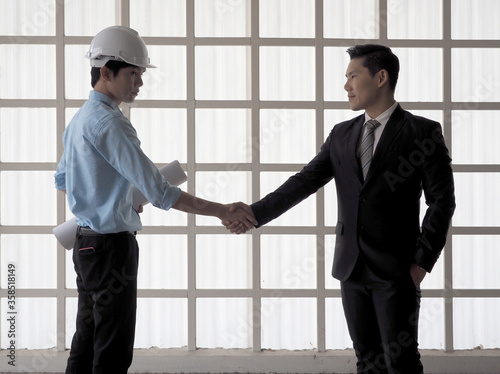 Businessman shake hand with engineer male or foreman or architects asian people.Symbol of success deal, happy partnership, greeting shake.