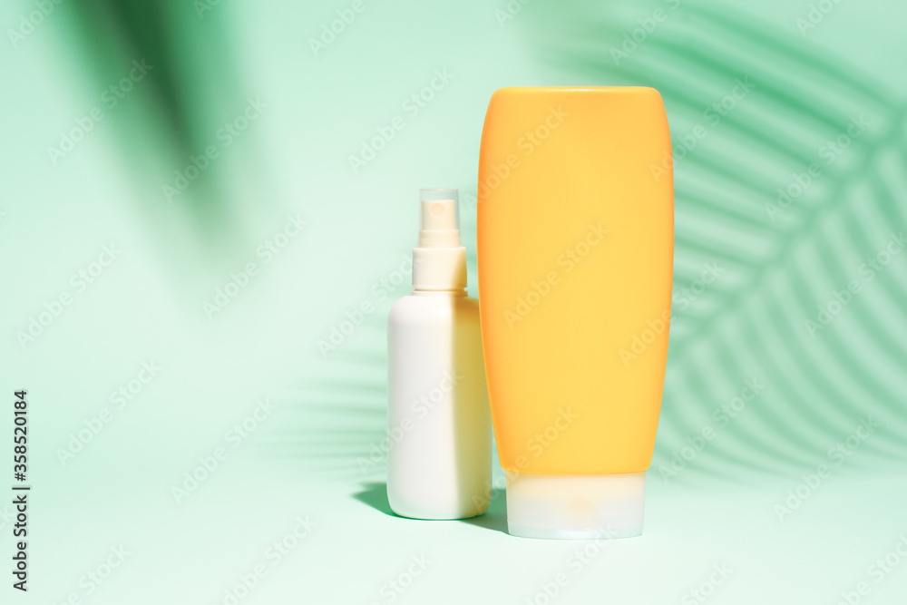White and orange spray containers without label on turquoise background White and orange spray containers without label on turquoise background