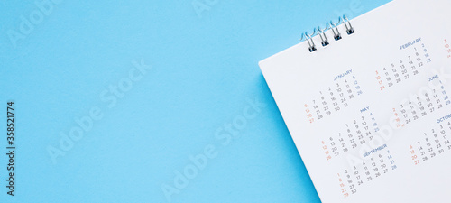 calendar page close up on blue background business planning appointment meeting concept