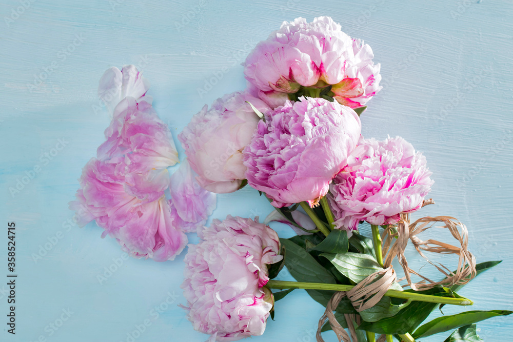 Pink peonies bouquet closeup, spring flowers for Mother's Day on ligh blue wooden background. Wedding events and other holidays. Pink peonies bouquet closeup, spring flowers for Mother's Day on ligh blue wooden background. Wedding events and other holidays.