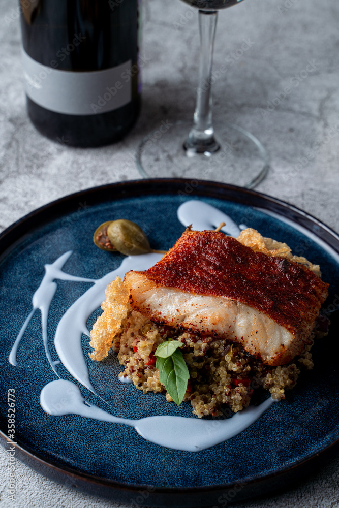 Fine dining restaurant: golden cod fillet with couscous and rice chips, garnished with unusual blue sauce Fine dining restaurant: golden cod fillet with couscous and rice chips, garnished with unusual blue sauce