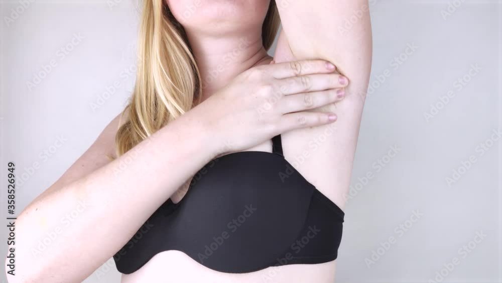 A woman suffers from pain in the armpit. Sweating, unpleasant odor