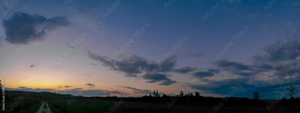 Fototapeta premium beautiful sunset with colorfully clouds close to the forest