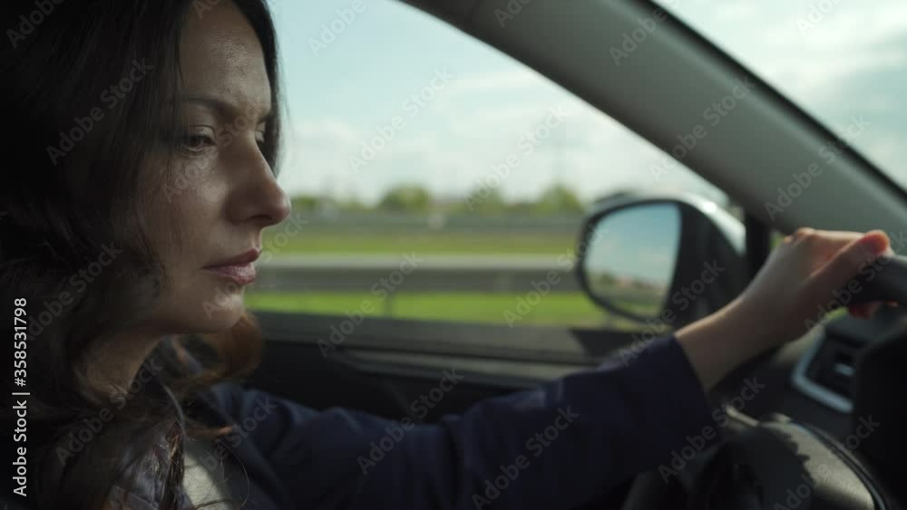 Beautiful brunette woman with long hair driving car on highway, side view of woman drives a automobile. Beautiful brunette woman with long hair driving car on highway, side view of woman drives a automobile.