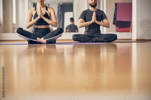 Man and a woman meditating in a lotus pose
